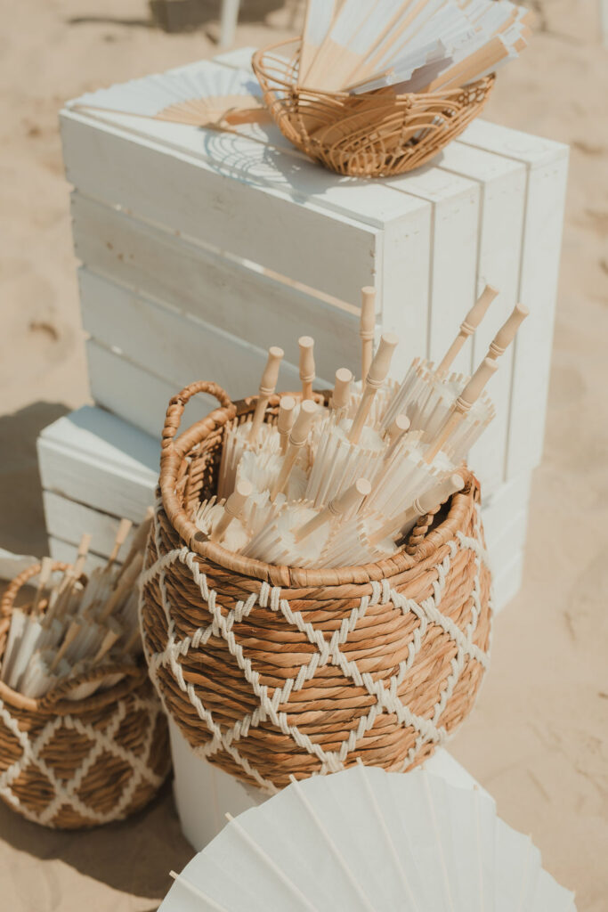 Körbe mit Fächern für die Gäste einer Strandhochzeit