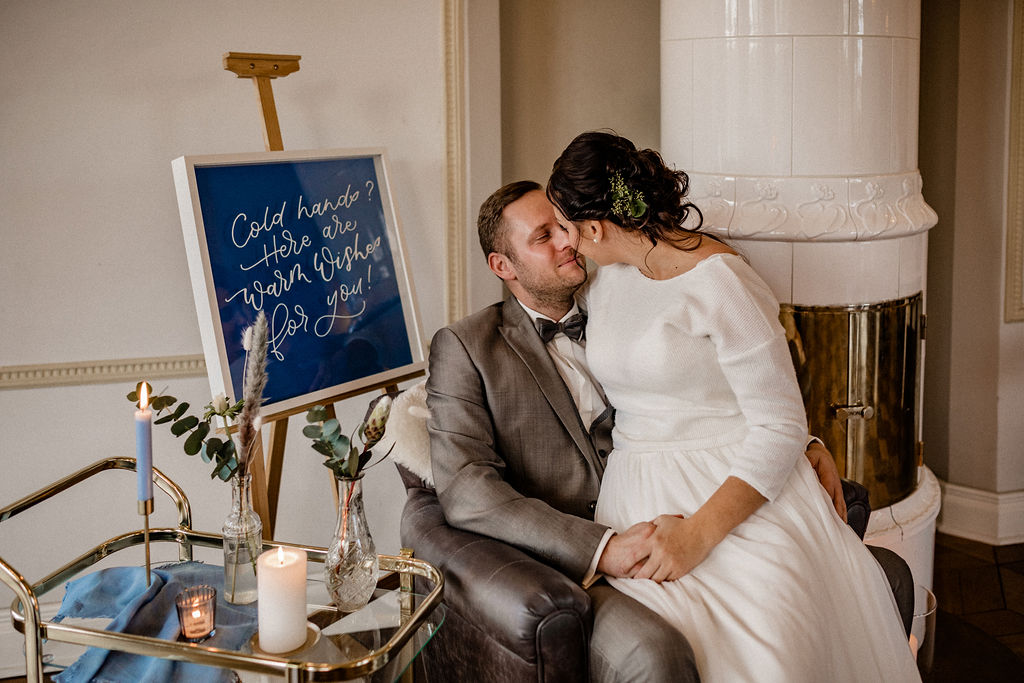 Brautpaar mit Willkommensschild beim Styled Shoot im Schloss Gamehl